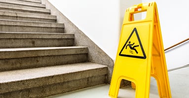 Wet floor sign at the bottom of staircase.